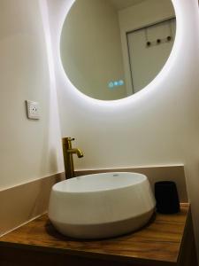 Un baño con un lavabo blanco y un espejo. en Chez Louise et Lucette, en Sanary-sur-Mer