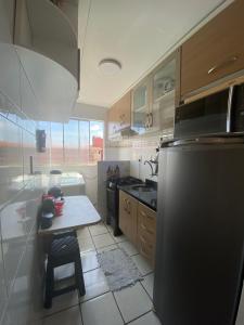 uma pequena cozinha com uma mesa e um frigorífico em Apto refugio 304 em Sao Luis - MA em São Luís