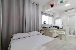 a white bedroom with a bed and a bathroom at Studios Modernos Totalmente Mobiliados com Academia Próximo a Metrô Parque Ibirapuera e Hospitais in Sao Paulo +141 photos