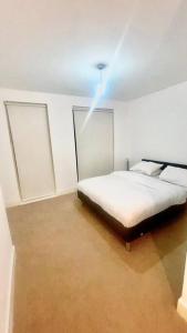 a bedroom with a bed and a light on the ceiling at Modern One Bedroom Luxury Apartment in Colindale