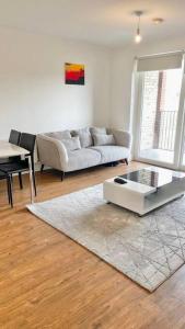 a living room with a couch and a table at Modern One Bedroom Luxury Apartment in Colindale