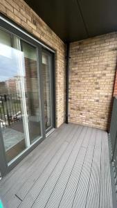 an empty patio with a brick wall and a window at Modern One Bedroom Luxury Apartment in Colindale