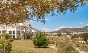 einen Blick auf ein Haus mit Bergen im Hintergrund in der Unterkunft Hacienda Riquelme Golf Resort Ground Floor Apartment in Sucina
