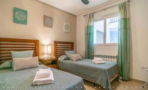 ein Schlafzimmer mit zwei Betten und einem Fenster in der Unterkunft Hacienda Riquelme Golf Resort Ground Floor Apartment in Sucina + 22 Fotos