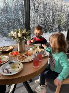 two children sitting at a table eating food at Шишка in Bukovel