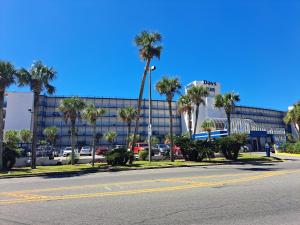 an empty street in front of a building with palm trees at Days Inn by Wyndham Panama City Beach/Ocean Front in Panama City Beach