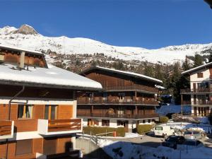 een gebouw met een met sneeuw bedekte berg op de achtergrond bij Instant sports & ski Paradise in Verbier