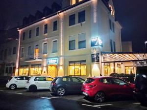 a group of cars parked in a parking lot in front of a building at Hotel Ariston in Lahnstein