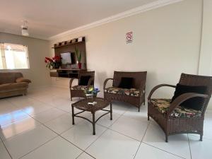 - un salon avec des chaises et un canapé dans l'établissement Estilo e conforto em região central, Foz do Iguaçu, à Foz do Iguaçu