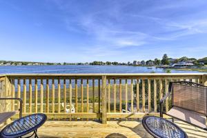 a deck with two chairs and a bench and a view of the water at Coastal Rhode Island Home with Kayaks, Deck and Grill! in Portsmouth