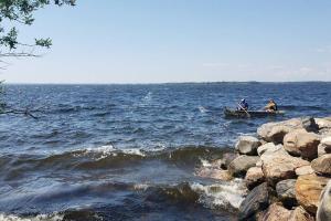 dos personas en un barco en un cuerpo de agua en Georgian Bay-Trail/Run/Bike/Hike/HotTub/Sauna/Swim, en Waubaushene