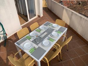 a table with plates and glasses on a patio at Los Seis Caños in Madrigal de la Vera