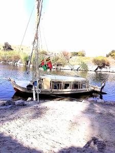 a boat sitting on the shore of a river at Nile Felucca Adventure in Aswan