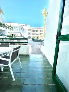 a patio with a table and chairs next to a building at Optimist Playa de Las Américas in Playa de las Americas
