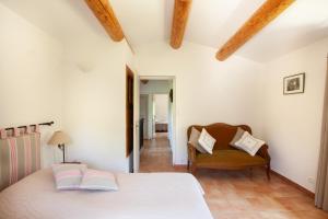 - une chambre avec un lit et une chaise dans l'établissement Gîte St Roch en Luberon, à Castellet