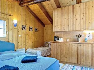 a room with two beds and wooden walls at Happiness only! in Bruson