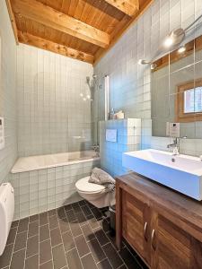La salle de bains est pourvue d'un lavabo, de toilettes et d'une baignoire. dans l'établissement Happiness only!, à Bruson