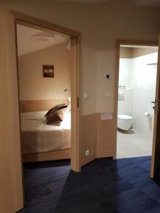 a bedroom with a bed and a bathroom with a toilet at Centrum Misji Afrykańskich - ośrodek hotelowo-konferencyjny in Borzęcin Duży