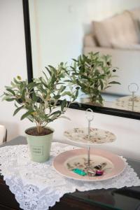 une table avec une plaque et une plante en pot dans l'établissement Messini Agrilia Residence, à Messini