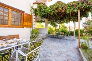 - une terrasse avec une table, des chaises et des fleurs dans l'établissement Messini Agrilia Residence, à Messini