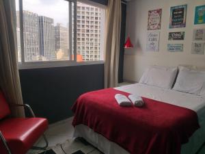 ein Schlafzimmer mit einem Bett mit zwei weißen Schuhen darauf in der Unterkunft Apartamento Bem Localizado Centro de SP in São Paulo