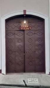 una grande porta marrone del garage con un cartello sopra di Casa Vieja Guest House a Santa Ana