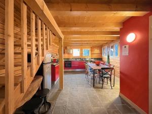 a kitchen with wooden ceilings and a table with chairs at Hakuna Matata - Family Apt - 4 Vallées - Swiss Alps in Bruson