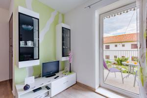 Il comprend un salon doté d'une télévision et d'une fenêtre. dans l'établissement Apartment Anamaris, à Solin