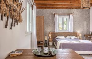 a bedroom with a bed and a table with wine glasses at Sophia's Ralaki Cottage in Ralaki