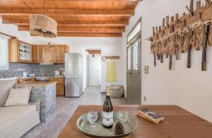 a kitchen and living room with a table with a bottle of wine at Sophia's Ralaki Cottage in Ralaki