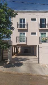 a large white building with balconies and a parking lot at Refúgio, paraquedismo, balão, 130 km de São Paulo in Pôrto Feliz