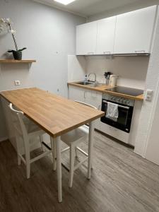 eine Küche mit einem Holztisch und weißen Schränken in der Unterkunft Ferienwohnung in Freudenstadt-Kniebis in Freudenstadt
