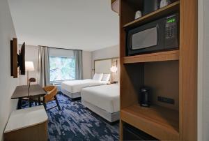 una camera d'albergo con due letti e una televisione di Fairfield by Marriott Inn & Suites Norfolk a Norfolk