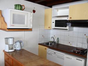 eine Küche mit einer Spüle und einer Mikrowelle in der Unterkunft Appartement Pralognan-la-Vanoise, 2 pièces, 4 personnes - FR-1-464-35 in Pralognan-la-Vanoise