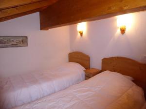 a bedroom with two beds and two lights on the wall at Duplex Mezzanine 6 Pers. avec Grand Balcon et Garage à 400m des Commerces et Téléphérique - FR-1-464-36 in Pralognan-la-Vanoise