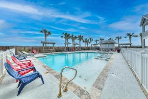 a swimming pool with lounge chairs and palm trees at Seaside Paradise in Corpus Christi
