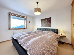 Schlafzimmer mit einem Bett und einem Fenster in der Unterkunft Our little marmots' dream in Bruson