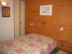 プラローニャン・ラ・ヴァノワーズにあるAppartement Pralognan-la-Vanoise, 3 pièces, 6 personnes - FR-1-464-49の木製の壁のベッドルーム1室(ベッド1台付)