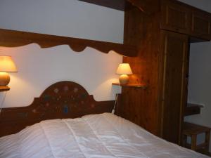 プラローニャン・ラ・ヴァノワーズにあるAppartement Pralognan-la-Vanoise, 3 pièces, 6 personnes - FR-1-464-55のベッドルーム1室(木製ベッド1台、ランプ2つ付)