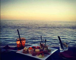 un plato de comida en una mesa junto al océano en Isola Bianca, en Isola delle Femmine