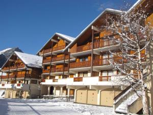 un grand immeuble avec de la neige au sol dans l'établissement Appartement Pralognan-la-Vanoise, 3 pièces, 6 personnes - FR-1-464-52, à Pralognan-la-Vanoise