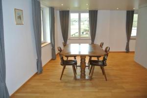阿彭策爾的住宿－Ferienwohnung Blaues Haus，一间带木桌和椅子的用餐室