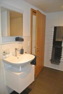 a white bathroom with a sink and a mirror at Ferienwohnung Blaues Haus in Appenzell
