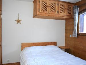 プラローニャン・ラ・ヴァノワーズにあるAppartement Pralognan-la-Vanoise, 3 pièces, 4 personnes - FR-1-464-70のベッドルーム1室(ベッド1台付)、木製キャビネットが備わります。