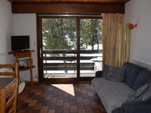 a living room with a couch and a sliding glass door at Studio Pralognan-la-Vanoise, 1 pièce, 4 personnes - FR-1-464-71 in Pralognan-la-Vanoise