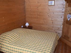 - une chambre avec un lit et un mur en bois dans l'établissement Appartement Pralognan-la-Vanoise, 3 pièces, 6 personnes - FR-1-464-85, à Pralognan-la-Vanoise