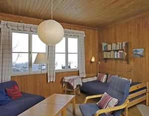 - un salon avec des canapés bleus et une table dans l'établissement Alpidyll Traditionelles 4 -Zimmer-Einzelchalet, à Hasliberg