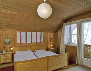 a bedroom with a bed and a large window at Alpidyll Traditionelles 4 -Zimmer-Einzelchalet in Hasliberg