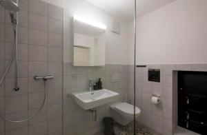 a bathroom with a sink and a toilet and a shower at Ferienwohnung Schloss Heidegg in Gelfingen