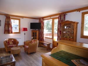 プラローニャン・ラ・ヴァノワーズにあるAppartement Pralognan-la-Vanoise, 2 pièces, 4 personnes - FR-1-464-107のリビングルーム(テレビ、ソファ、椅子付)